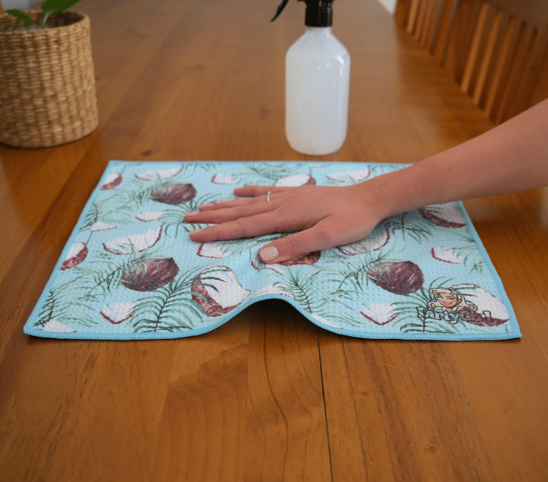 Hand wiping kitchen surface with DirtyGirl Coconut Glow Cloth – Lint-free finish