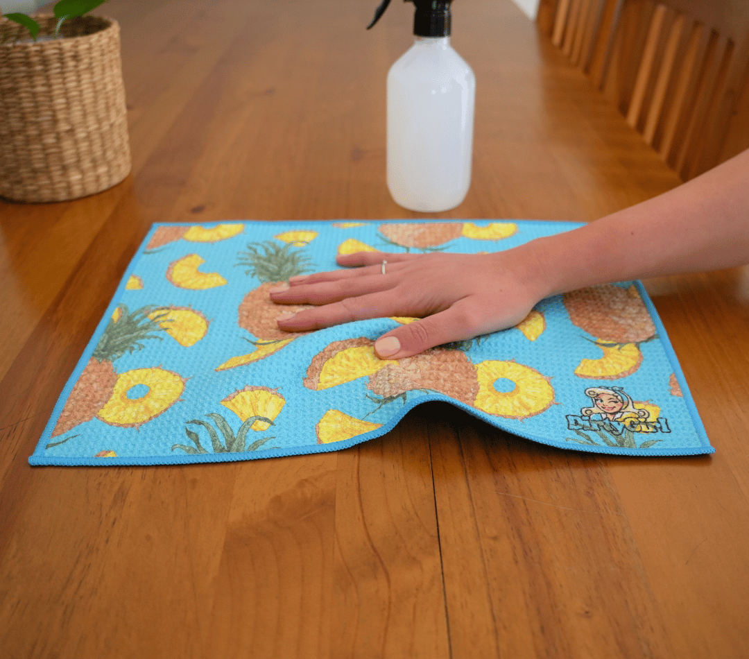 Hand wiping kitchen surface with DirtyGirl Pineapple Express Cloth – Lint-free finish